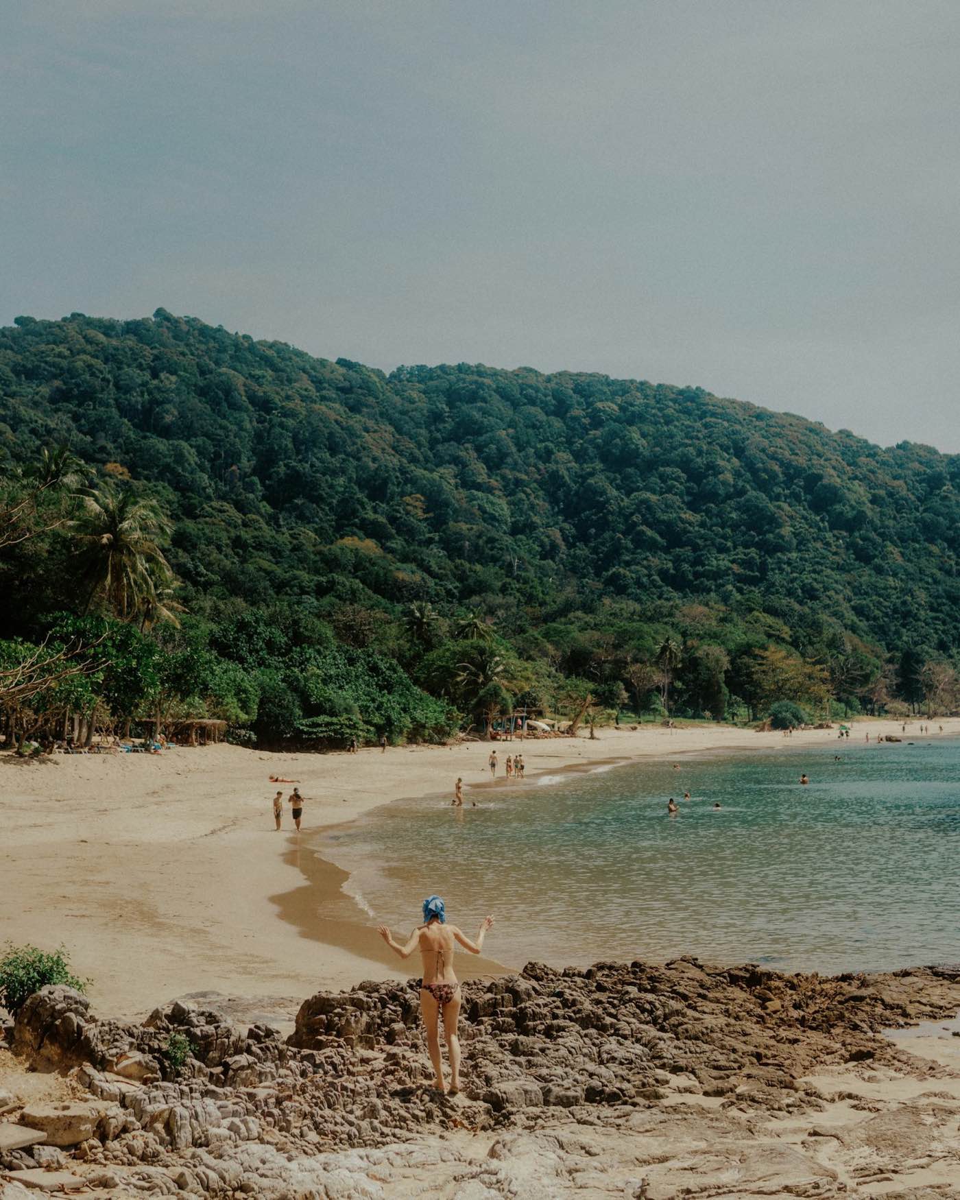 Travelers enjoying a beautiful Costa Rica beach with forested hills