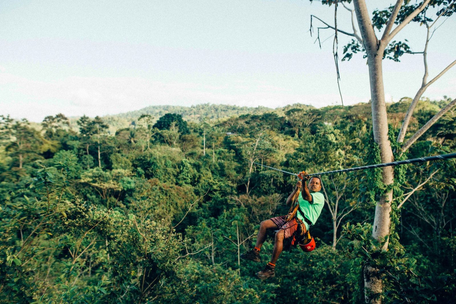 Woman zip-lining through the Costa Rica rainforest canopy
